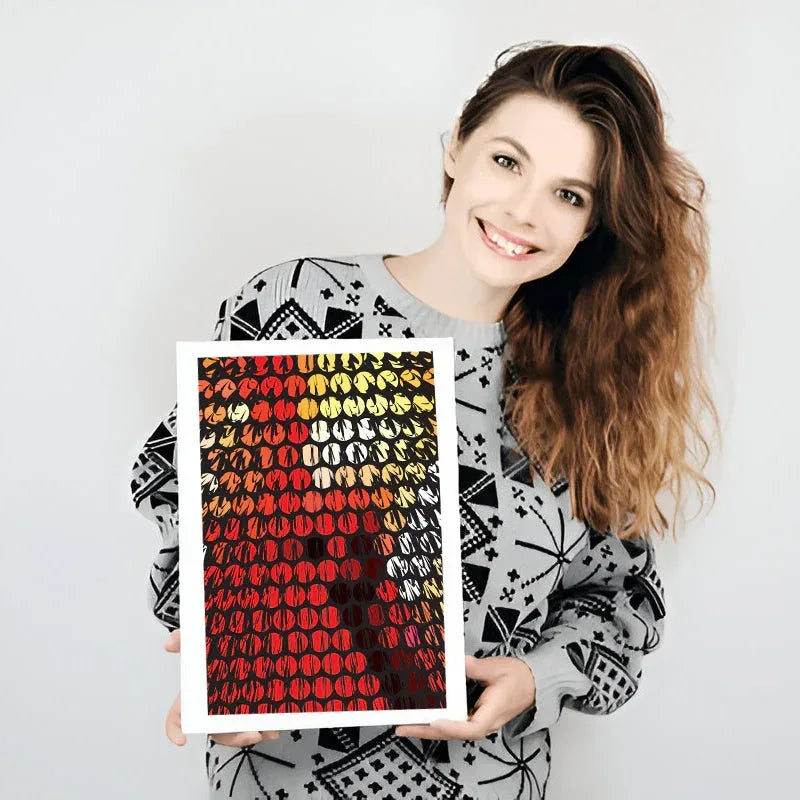 Woman holding a framed artwork with a colorful pattern on a white background