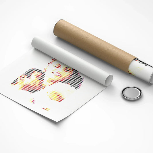 Unrolled cross-stitch pattern with a cardboard tube and metal button on a white background