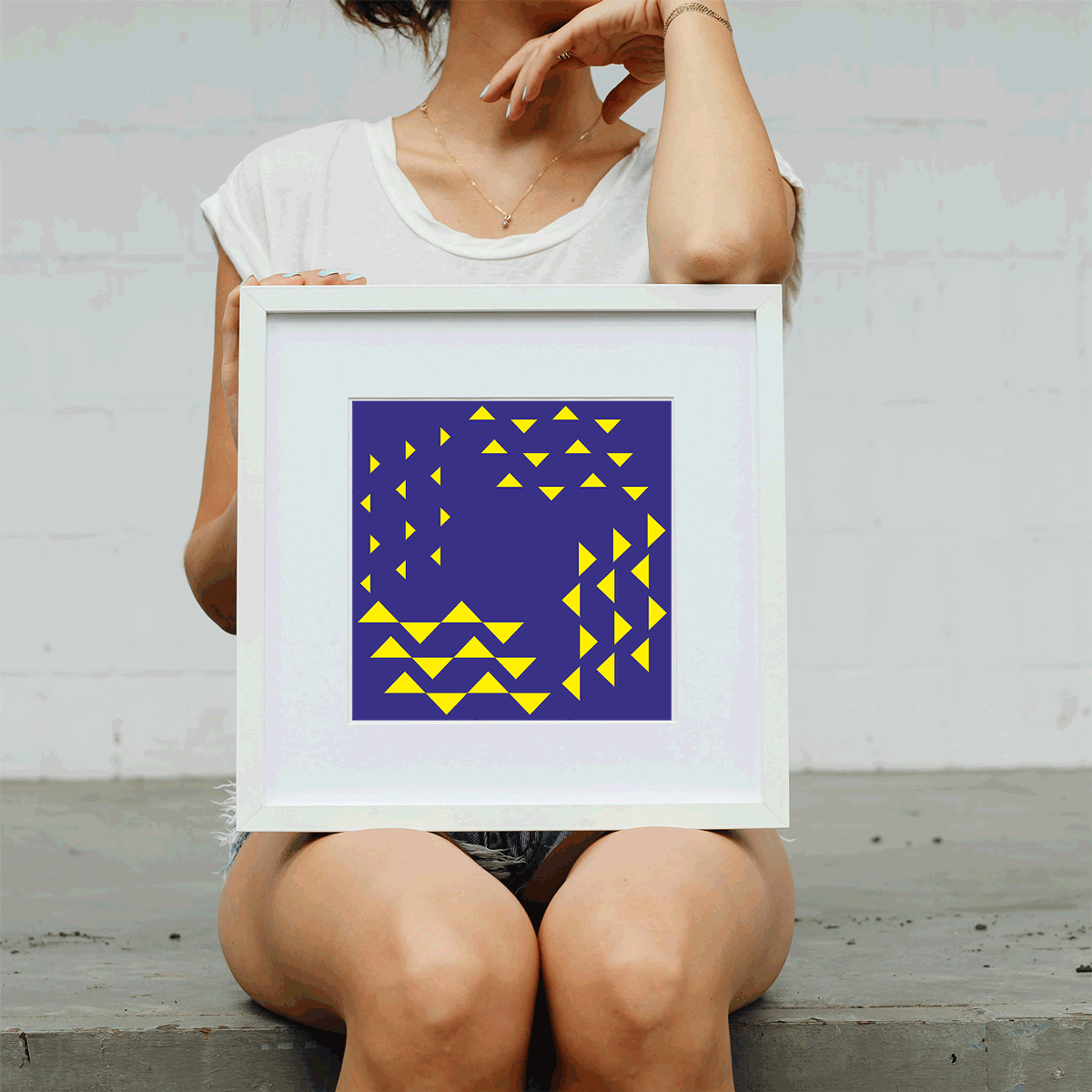 Person holding a framed artwork with geometric design