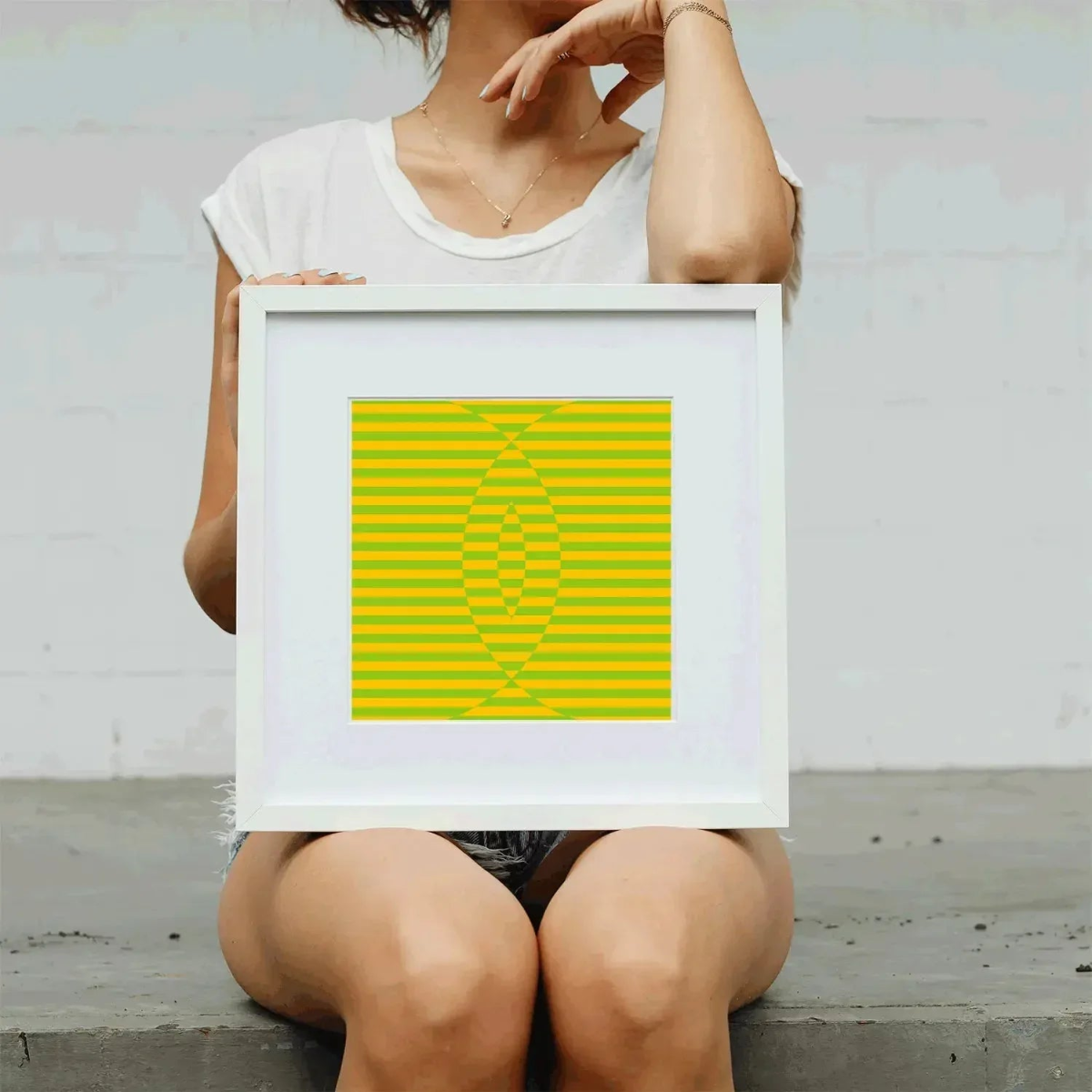 Person holding a framed artwork with geometric design