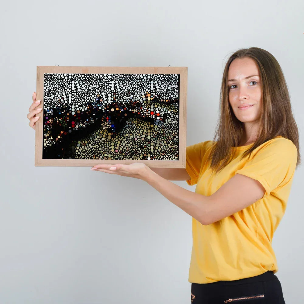 Woman holding a framed artwork against a plain background