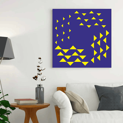 Geometric abstract art piece with yellow triangles on a blue background in a living room setting.