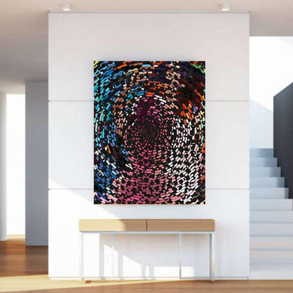 Abstract multicolored artwork on a white wall above a wooden console table.