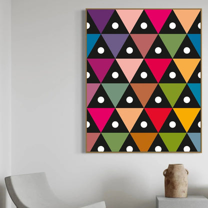 Geometric triangle pattern with white dots on a plain wall with a chair and vase.