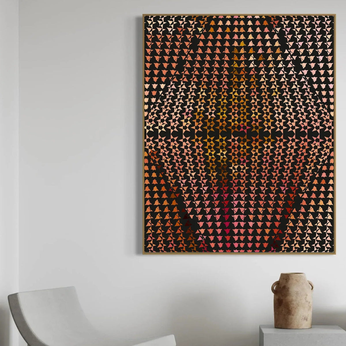 Abstract art piece with geometric pattern on a white wall, featuring a chair and vase in the foreground.