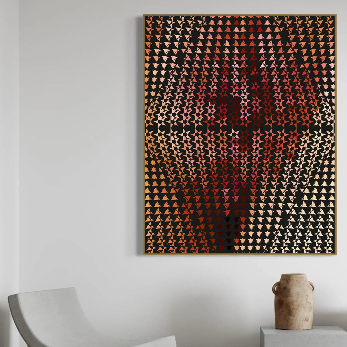 Abstract art piece with geometric pattern on a white wall, featuring a chair and vase in the foreground.