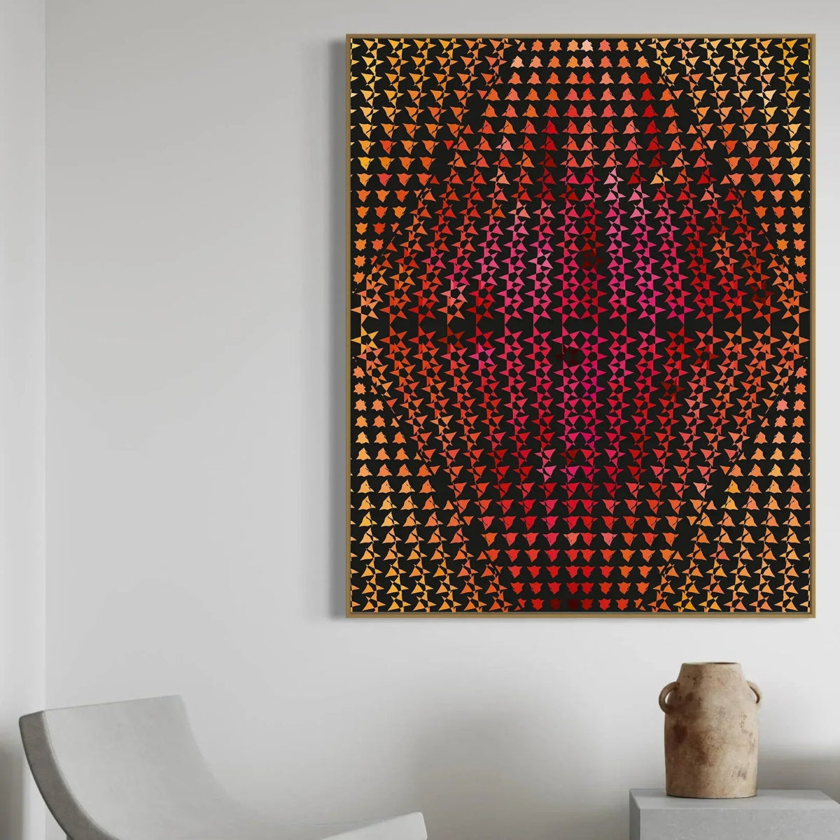 Abstract art piece with geometric pattern on a white wall, featuring a chair and vase in the foreground.