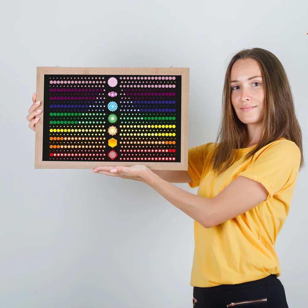Woman holding a colorful board with various colored circles against a plain background