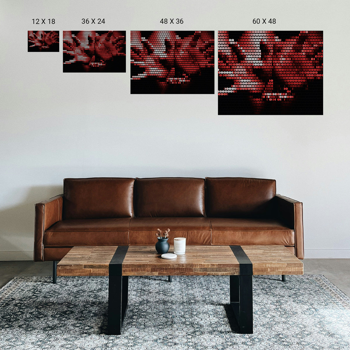 Brown leather sofa in a living room with a wooden coffee table and four sizes of abstract red and black wall art above.