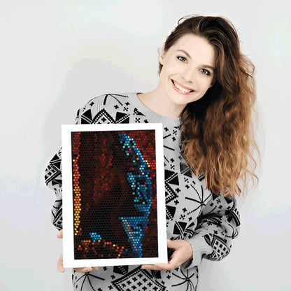 Woman holding a framed mosaic art piece with colorful design on a white background