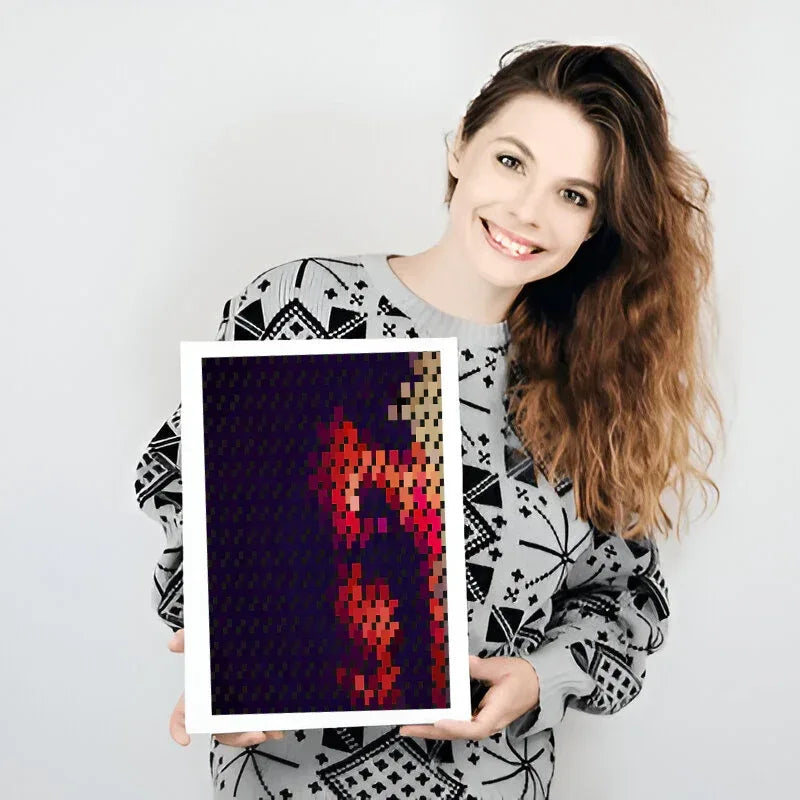 Woman holding a framed pixel art piece against a plain background