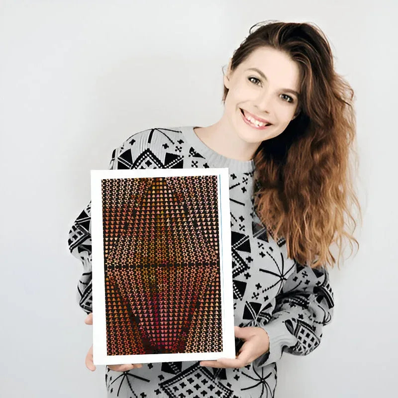 Woman holding a framed patterned artwork against a plain background