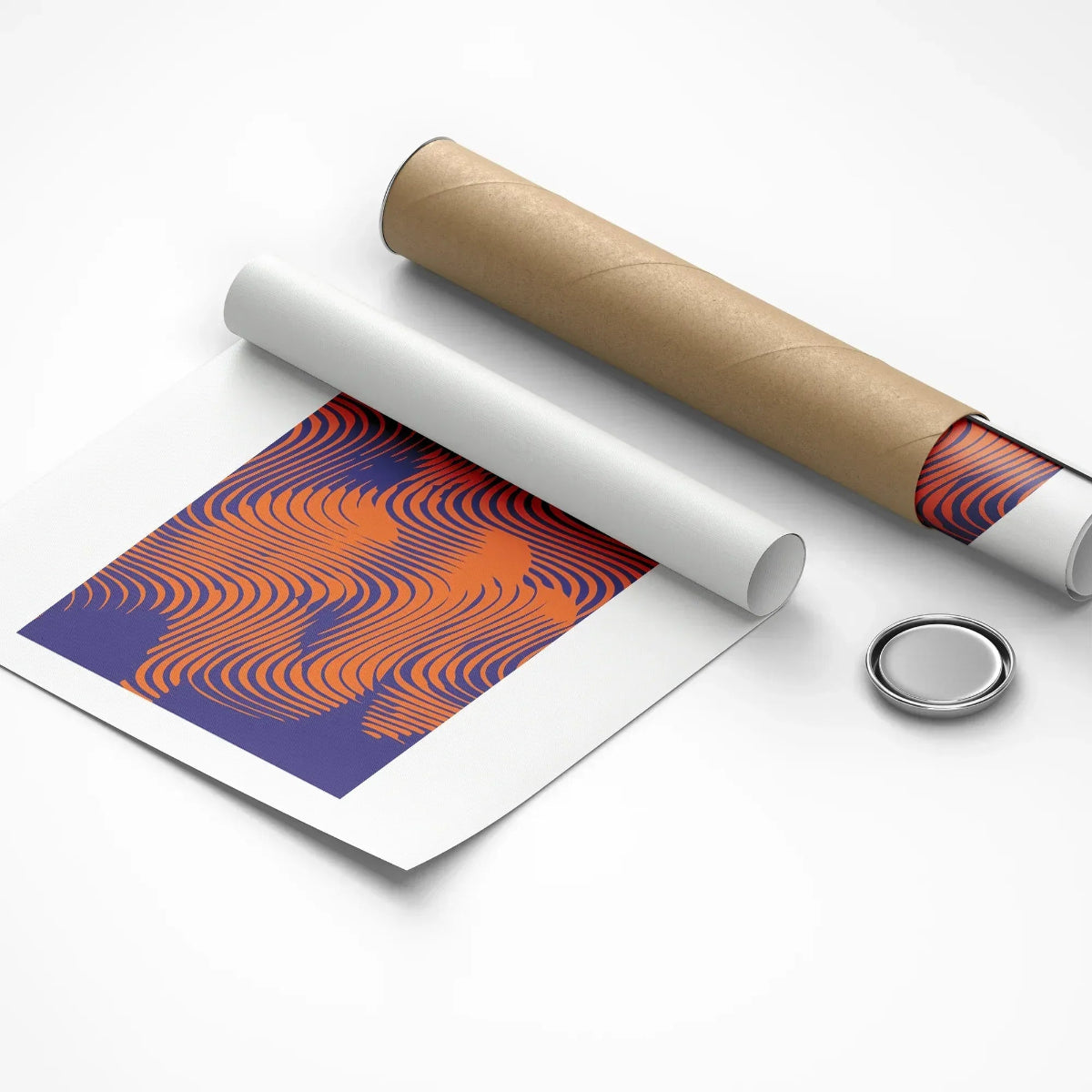 Roll of paper with a pattern, cardboard tube, and round metallic object on a white background