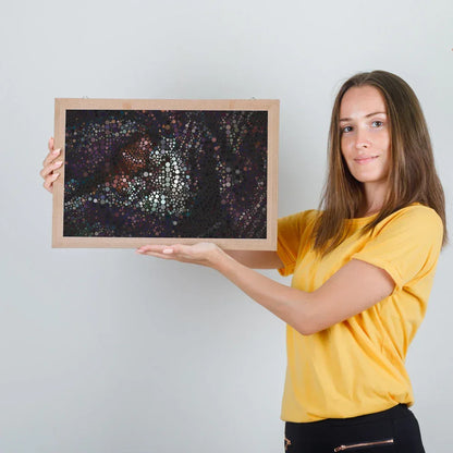 Woman holding a framed artwork against a plain background