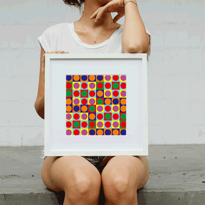 Person holding a framed colorful geometric art print against a plain background