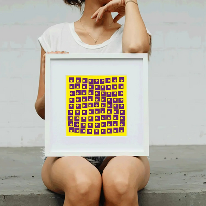 Person holding a framed artwork with a geometric pattern