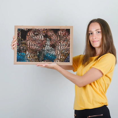 Woman holding a framed artwork against a plain background