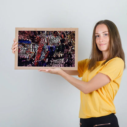 Woman holding a framed artwork with a colorful abstract design on a plain background